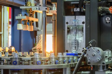 Küf makinesiyle içme suyu üretme işlemi. Plastik şişe üfleme makinesi operasyonu..