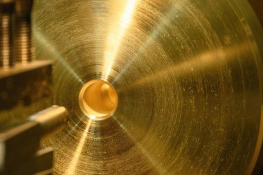 Torna makinesinin pirinç maddi parçalarının bitiş sahnesi. Makineyi döndürerek metal işleme süreci.