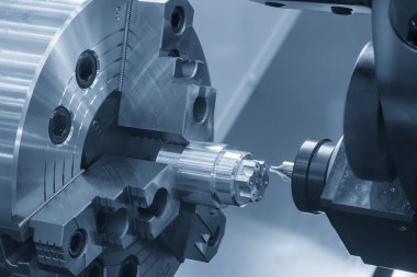 CNC torna makinesi Chamfer değirmeni metal şaft parçalarını kesmiş. CNC dönüşüm makinesiyle çalışan yüksek teknoloji metali.