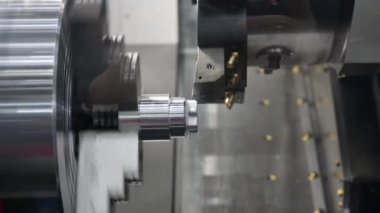 CNC torna makinesi metal şaft parçalarını kesiyor. CNC dönüşüm makinesinin yüksek teknolojili metal işlemesi .