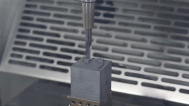 CNC değirmen makinesi düz uçlu değirmen aracıyla grafit elektrot parçalarını kesiyor. CNC makine merkezi tarafından üretilen kalıp ve ölüm süreci.