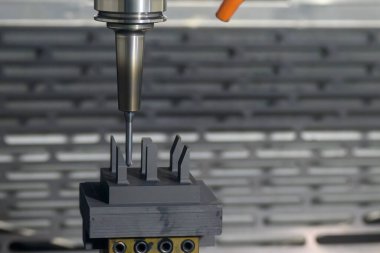 CNC değirmen makinesi grafit elektrot parçalarını kesiyor. CNC makine merkezi tarafından üretilen kalıp ve ölüm süreci.