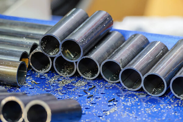 The piles of steel pipe cutting by band saw machine. The parts of steel pipe material for machining process.