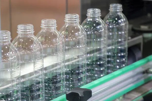 The hi-technology of drinking water manufacturing process. The  empty drinking water bottles  on the conveyor belt for filling process.