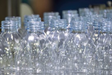 İçme suyu üretim sürecinin yüksek teknolojisi. Taşıma bandındaki boş içme suyu şişelerini doldurmak için.. 