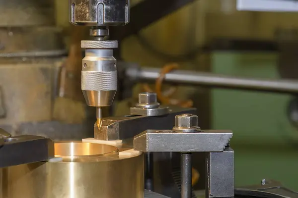 The drilling process on NC milling machine with brass material. The metal working concept on the milling machine.