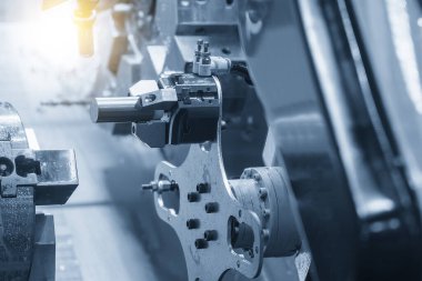 CNC torna makinesinin metal parçalarını tutan otomatik robot kolu. Dönüşüm makinesinde robotik sistem tarafından yüksek teknoloji materyal işleme süreci. 