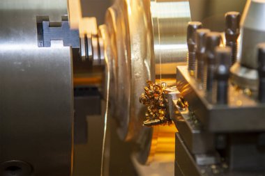 Closeup scene the lathe machine finish cut the brass parts by lathe tools. The metalworking process by turning machine.