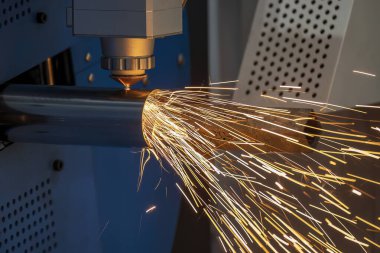 Sahneyi kapatın, fiber lazer kesme makinesi paslanmaz çelik tüpü ve parlak ışığı kesti. Lazer kesme makinesinin yüksek teknoloji metal üretim süreci.. 