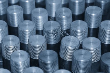 Sahneyi kapatın. Açık mavi sahnedeki metal damızlık parçaları. Tesisatçı kısmı üretim konsepti..