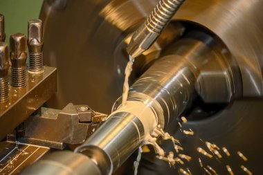 Torna makinesi metal şaft parçalarını sıvı soğutucu metoduyla kesiyor. Makineyi döndürerek metal işleme süreci.