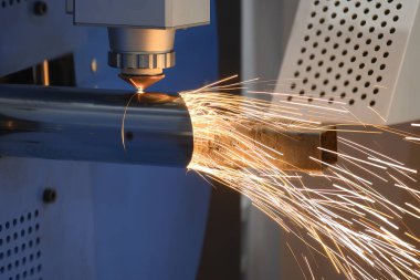 Sahneyi kapatın, fiber lazer kesme makinesi paslanmaz çelik tüpü ve parlak ışığı kesti. Lazer kesme makinesinin yüksek teknoloji metal üretim süreci.. 