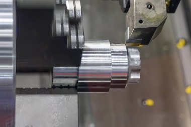 CNC torna makinesi metal şaft parçalarını kesiyor. CNC dönüşüm makinesinin yüksek teknolojili metal işlemesi .