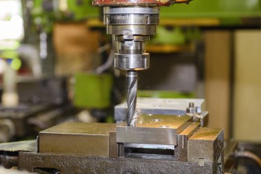 The drilling process on NC milling machine with brass material. The metal working concept on the milling machine.