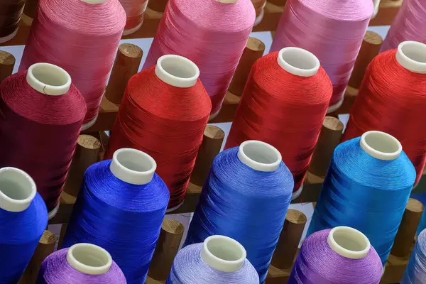 Close up the multi-color group of industry bobbin thread. The textile production concept.