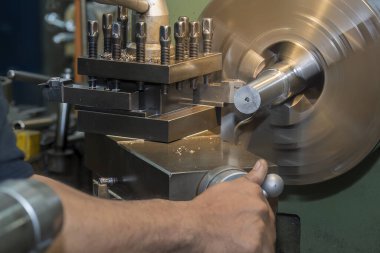 Torna makinesini çalıştıran makine operatörü. Dönüş makinesiyle mağaza katında işlem.