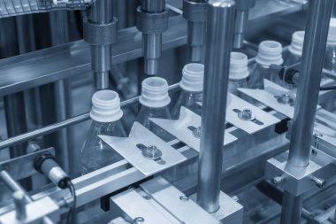 İçme suyu üretim sürecinin yüksek teknolojisi. Taşıma bandındaki boş içme suyu şişelerini doldurmak için.. 