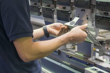 Bükme makinesi operatörünü kapatın metal levha parçalarını tutun. Yetenek operatörünün kullandığı levha metal çalışması.