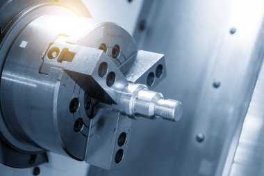 CNC torna makinesi ışık efektiyle açık mavi sahnedeki metal şaft parçalarını kesiyor. CNC dönüşüm makinesinin yüksek teknolojili metal işlemesi .