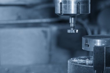 Açık mavi sahnede T-slot kesicisiyle NC değirmen makinesindeki T-slot kesme işlemi. Değirmen makinesindeki metal çalışma konsepti..