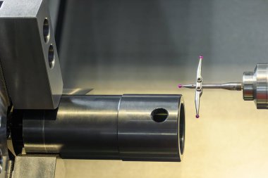 Modüler dokunmatik sonda CNC torna makinesindeki tüp parçalarını kontrol ediyor. Parçaları CMM sondasıyla döndürmenin kalite kontrolü.