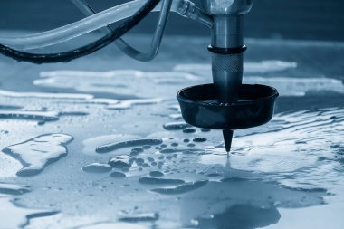 Aşındırıcı su jeti kesme makinesi açık mavi sahnede metal plakayı kesiyor. CNC makinesiyle çalışan yüksek teknoloji levha metali.