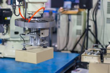 Karton kutu işleme işlemi robot sistemle yapılır. Yüksek teknoloji materyal işleme süreci robotik kol ile.