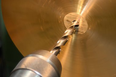 Torna makinesiyle pirinç maddi parçaları delme işlemi. Çevirme makinesindeki parça üretimi. 