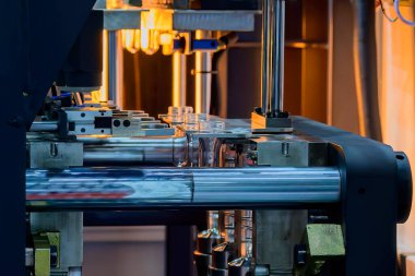 Küf makinesiyle içme suyu üretme işlemi. Plastik şişe üfleme makinesi operasyonu..