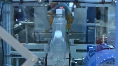 Taşıyıcı banttaki boş içme suyu şişeleri doldurmak için. İçme suyu doldurma işleminin yüksek teknolojisi. 