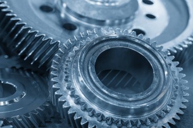 Açık mavi sahnedeki şanzıman parçalarını kapatın. Otomotiv vites kutusu üretim süreci kavramı.