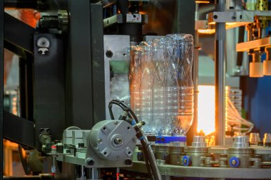 Küf makinesiyle içme suyu üretme işlemi. Plastik şişe üfleme makinesi operasyonu..