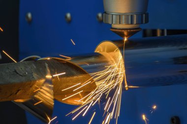 Sahneyi kapatın, fiber lazer kesme makinesi paslanmaz çelik tüpü ve parlak ışığı kesti. Lazer kesme makinesinin yüksek teknoloji metal üretim süreci.. 