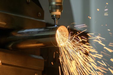 Sahneyi kapatın, fiber lazer kesme makinesi paslanmaz çelik tüpü ve parlak ışığı kesti. Lazer kesme makinesinin yüksek teknoloji metal üretim süreci.. 