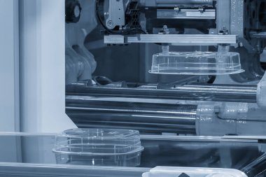 Plastik enjeksiyon küf makinesinden otomatik sistem tarafından üretilen yiyecek kutusu. Robotik sistem tarafından enjeksiyon makinesinden materyal işleme süreci. 