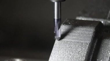 Kapanış sahnesinde CNC değirmen makinesi basını kesiyor. Kalıplar, sert top değirmeni ile makine merkeziyle kesme işlemi yapıyor.
