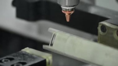 Sahneyi kapatın, fiber lazer kesme makinesi paslanmaz çelik kare tüpü ve parlak ışığı kesti. Lazer kesme makinesinin yüksek teknoloji metal üretim süreci.. 