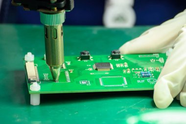 Sahneyi kapat. PCB tahtası operatör tarafından kontrol ediliyor. Elektronik endüstrisinin devre kartının kalite kontrolü.