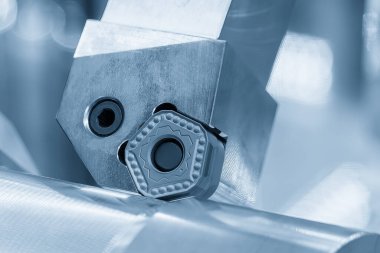 Açık mavi sahnedeki torna makinesinin çipini kapat. Yüksek hassasiyetli mekanik parça üretim konsepti.