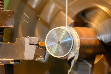 Torna makinesi metal şaft parçalarını sıvı soğutucu metoduyla kesiyor. Makineyi döndürerek metal işleme süreci.