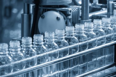 İçme suyu üretim sürecinin yüksek teknolojisi. Taşıma bandındaki boş içme suyu şişelerini doldurmak için.. 