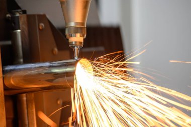 Sahneyi kapatın, fiber lazer kesme makinesi paslanmaz çelik tüpü ve parlak ışığı kesti. Lazer kesme makinesinin yüksek teknoloji metal üretim süreci.. 