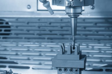 CNC değirmen makinesi açık mavi renkteki grafit elektrot parçalarını kesiyor. CNC makine merkezi tarafından üretilen kalıp ve ölüm süreci.