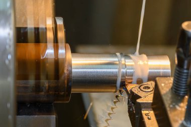 Torna makinesi metal şaft parçalarını sıvı soğutucu metoduyla kesiyor. Makineyi döndürerek metal işleme süreci.