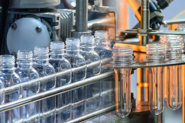 Soyut sahne, içme suyu şişesi üfleme makinesiyle üretim işlemi. Plastik şişe üfleme makinesi operasyonu..