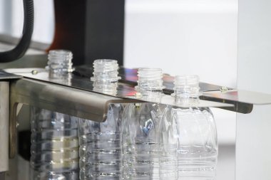 İçme suyu üretim sürecinin yüksek teknolojisi. Taşıma bandındaki boş içme suyu şişelerini doldurmak için.. 