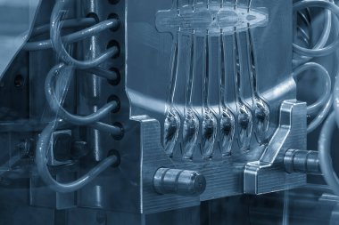 Plastik enjeksiyon sahnesini kapatın. Açık mavi sahnede küf parçaları. İğne makinesiyle kaşık üretimi kavramları.