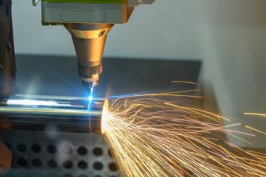 Sahneyi kapatın, fiber lazer kesme makinesi paslanmaz çelik tüpü lazer ışını ışığıyla kesti. Lazer kesme makinesinin yüksek teknoloji metal üretim süreci.. 
