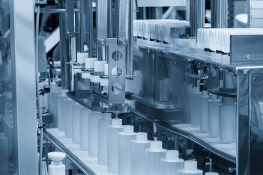 Taşıyıcı banttaki boş sağlık şişeleri doldurma işlemi için. Kozmetik şişe üretim sürecinin yüksek teknolojisi. 