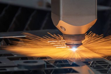 Sahneyi kapatın, fiber lazer kesme makinesi parlak ışıkla metal plakayı kesiyor. Lazer kesme makinesinin yüksek teknoloji metal üretim süreci.. 